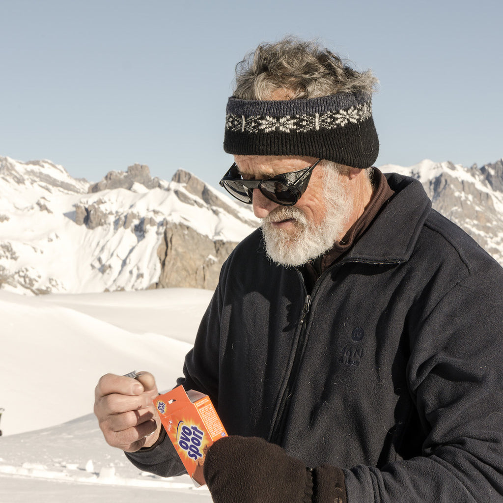 Roland Cachot avec les lunettes de soleil Moiry Black Glacier mangeant Ovo Sport lors d'une randonnée à ski